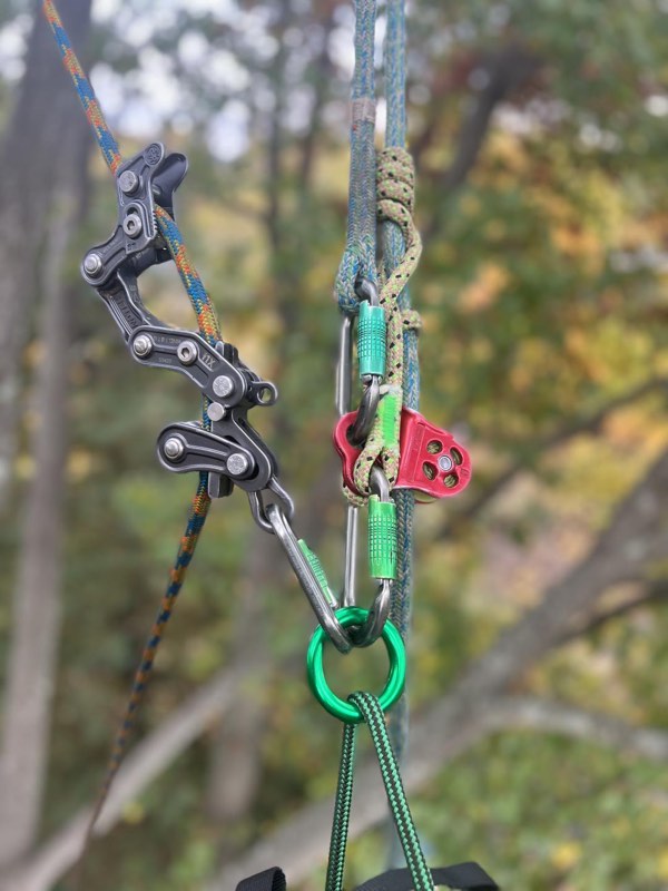 Close-up of climbing hardware -- rope wrench, carabiners and friction saver